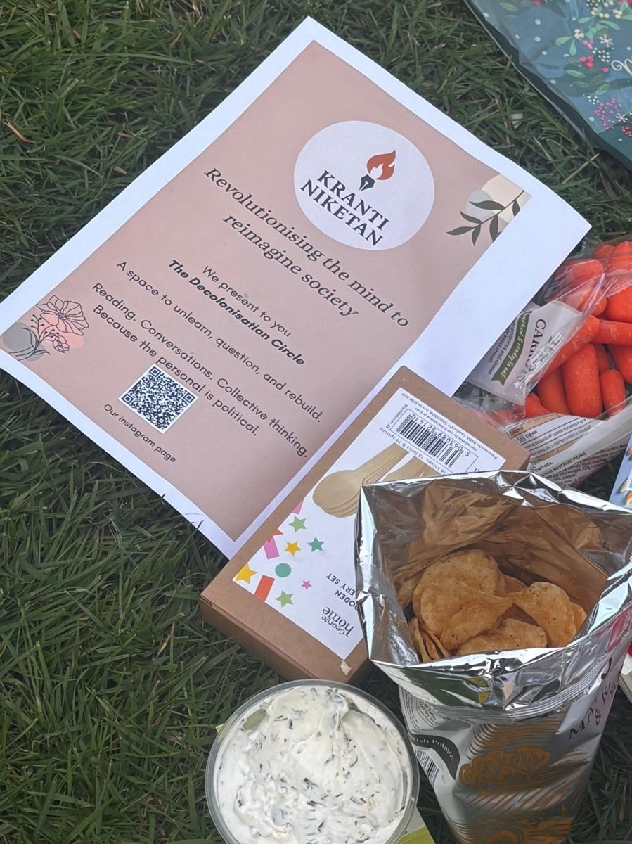 The Decolonisation Circle flyer on the grass among picnic food