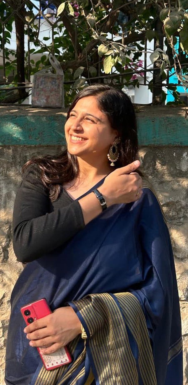 Heer Rughani, smiling in a white embroidered saree